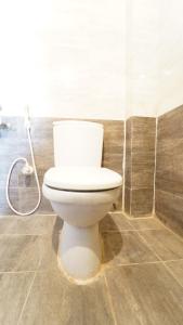 a white toilet in a bathroom with a shower at Aangal residency in Coimbatore