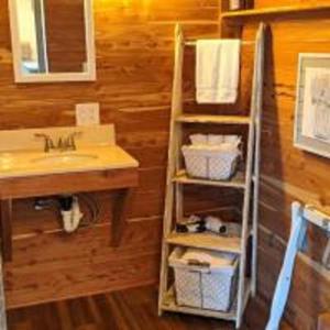 a bathroom with a sink and a shelf with towels at Tiny House with Amazing Views and Private Hiking Trails in Hill Country, Texas in Freedom Springs Ranch Airport