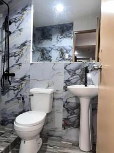 a bathroom with a toilet and a sink at Ace Travellers Inn- Palawan in Puerto Princesa City