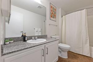 a white bathroom with a sink and a toilet at New Skywalk Access- Downtown Work Retreat- Sleeps8 in Indianapolis +49 photos