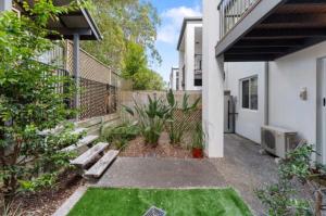 a garden with a bench in front of a house at Syldah Stay Mango Hills in North Lakes