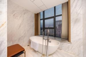 a bathroom with a tub and a large window at WYNDHAM TAIYUAN in Taiyuan