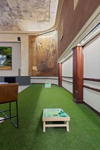 a room with green carpet and a table in it at New Skywalk Access- Downtown Work Retreat- Sleeps8 in Indianapolis