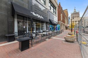 a store on a city street with benches in front at New Skywalk Access- Downtown Work Retreat- Sleeps8 in Indianapolis