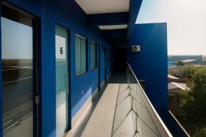 a hallway of a blue building with a balcony at Pousada do Andrade in Ponta Porã