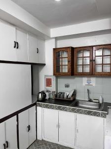 a kitchen with white cabinets and a sink at Ace Travellers Inn- Palawan in Puerto Princesa City +75 photos