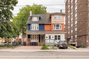 ein Haus in einer Straße mit einem davor geparkten Auto in der Unterkunft King West - Homestay - Main Floor - Private Room, Share Bathroom in Toronto