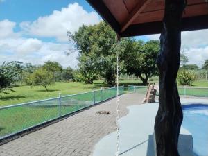 a porch with a swing next to a swimming pool at Casa Relax La Fortuna in Fortuna +9 photos