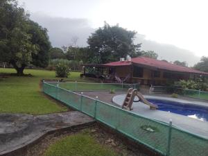 a pool with a slide in a yard with a house at Casa Relax La Fortuna in Fortuna