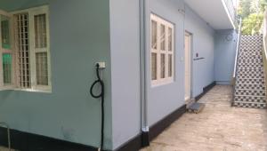 KunnamkulamCharis Guest house near Guruvayur, Kunnamkulam的房屋的走廊，有门和楼梯。 更多9张照片