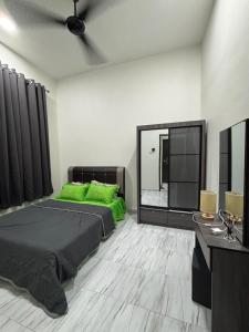 a bedroom with two green beds and a mirror at D Bukit homestay in Ketereh