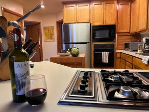 - une bouteille de vin assise sur un comptoir près d'une cuisinière dans l'établissement Blue Jay's Nest Sequoia Cabin in Ponderosa, CA, à Ponderosa