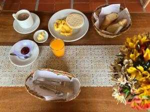 InzáLa Portada en Tierradentro Restaurante y Hospedaje的一张桌子上摆着一盘盘食物和一篮面包