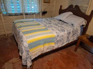 a bed with a blanket on it in a bedroom at Casa Bonsai in Chetumal