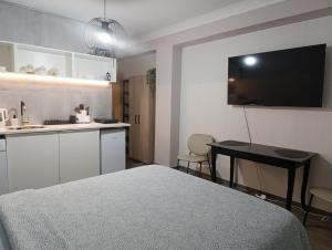 a bedroom with a bed and a table and a kitchen at Beach apartment's in Limassol