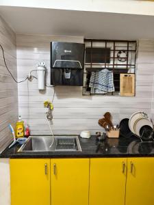 een keuken met gele kasten en een wastafel bij Ideal 2BHK for Families & Work Trips in Bangalore +18 foto's