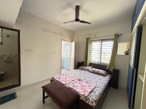 een slaapkamer met een bed en een plafondventilator bij Ideal 2BHK for Families & Work Trips in Bangalore