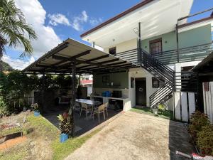 ein Haus mit einer Terrasse mit Tisch und Stühlen in der Unterkunft Bloom&Blossom in Iloilo City