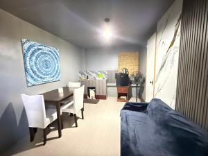 ein Esszimmer mit einem Tisch und weißen Stühlen in der Unterkunft Bloom&Blossom in Iloilo City