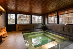 a swimming pool in a room with windows at Villa Amara & Private Spa in Rovaniemi