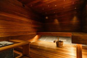 an empty wooden sauna with a bucket in it at Villa Amara & Private Spa in Rovaniemi
