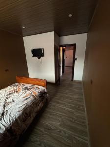 een slaapkamer met een bed en een flatscreen-tv bij Departamento Campestre in Ibarra +2 foto's