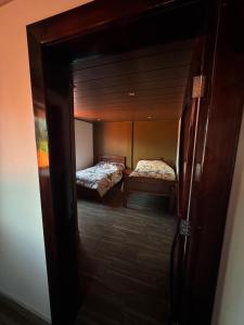 een kamer met 2 bedden en een deur open bij Departamento Campestre in Ibarra