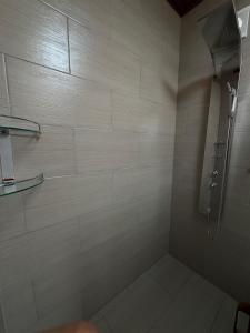 een badkamer met een douche met witte tegels bij Departamento Campestre in Ibarra