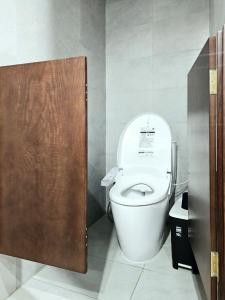 Un baño con un inodoro blanco en una cabina. en Wins Residences Hanoi, en Hanói 32 fotos más