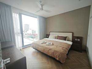 Un dormitorio con una cama grande y una ventana grande en Wins Residences Hanoi, en Hanói