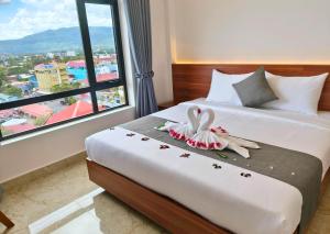 a hotel room with a bed with two swans on it at KKP Hotel in Kampot +48 photos