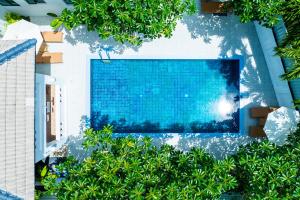 een uitzicht over een zwembad omgeven door bomen bij Phuket Leisure Time Hotel in Rawai Beach +129 foto's