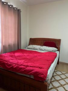 a bedroom with a bed with a red blanket at Shiv Tattva Yog School in Burhānilkantha +4 photos