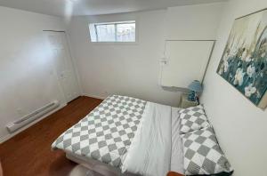 una camera da letto con un letto con una coperta a quadri di Cozy home a Calgary