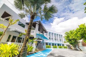 een palmboom voor een gebouw bij Phuket Leisure Time Hotel in Rawai Beach