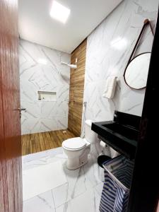 a bathroom with a sink and a toilet and a piano at Casa de condomínio em Paripueira com piscina e perto da praia in Paripueira