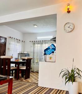 a living room with a clock on a wall at Himalayan Tranquil Stay in Burhānilkantha +1 photo