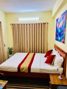a bedroom with a bed with red pillows at Himalayan Tranquil Stay in Burhānilkantha