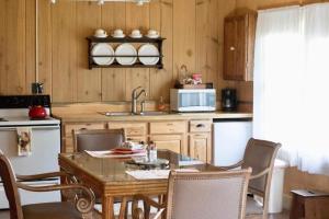 Una cocina con una mesa y sillas y un fregadero. en Rustic Cabin Rental in a Wild Meadow near Crater Lake National Park, Oregon, en Prospect