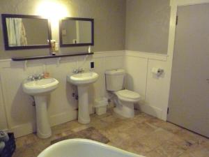 Un baño con dos inodoros, un lavabo y un espejo. en Rustic Cabin Rental in a Wild Meadow near Crater Lake National Park, Oregon, en Prospect