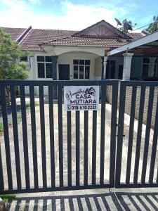 a sign on a gate in front of a house at Homestay Casa Mutiara in Paka