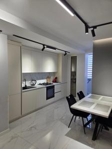 Una cocina y un comedor con mesa y sillas. en Транзит Сервис 3 Аэропорт- Кишинёв, en Chişinău