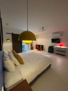 a bedroom with a large white bed with a yellow light at The Lamoon Residence samui in Lamai