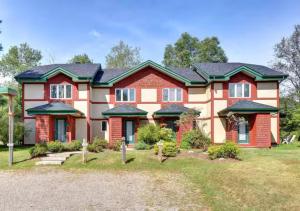 een groot rood-wit huis met een tuin bij Tremblant Classic Chalet La Bête Golf Course in Mont-Tremblant