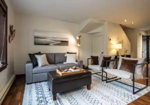 een woonkamer met een bank en een tafel bij Tremblant Classic Chalet La Bête Golf Course in Mont-Tremblant