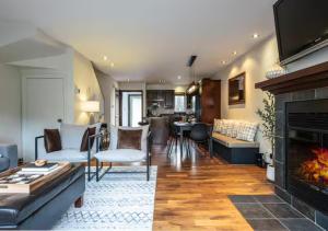 een woonkamer met een bank en een open haard bij Tremblant Classic Chalet La Bête Golf Course in Mont-Tremblant