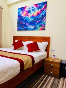a bedroom with a bed and a painting on the wall at Himalayan Tranquil Stay in Burhānilkantha