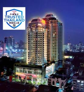 a city skyline with a tall building at night at Grand Diamond Suites Hotel in Bangkok