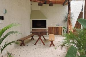 a patio with a table and a bench and a television at Casa Wayra Tulum - Boutique Condos in Tulum