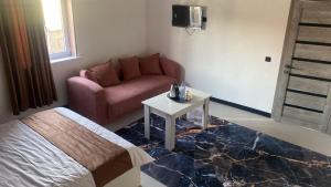 ein Zimmer mit einem Bett, einer Couch und einem Tisch in der Unterkunft Madani in Arys